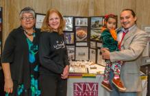 A group of people smiling in front of a display