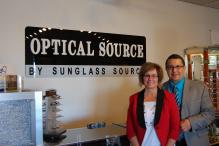 Couple standing next to banner with store name