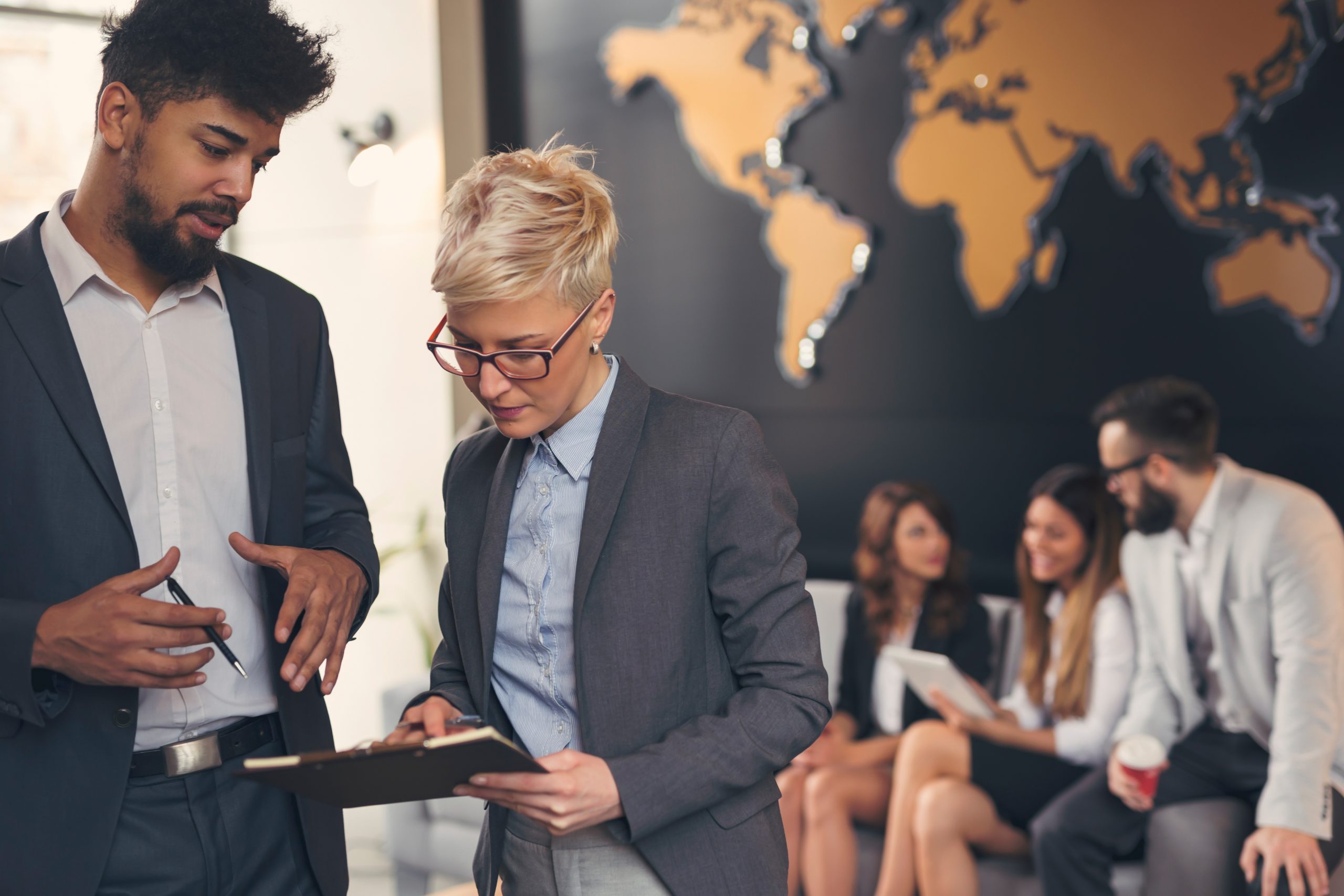 two people looking at report in front of world map