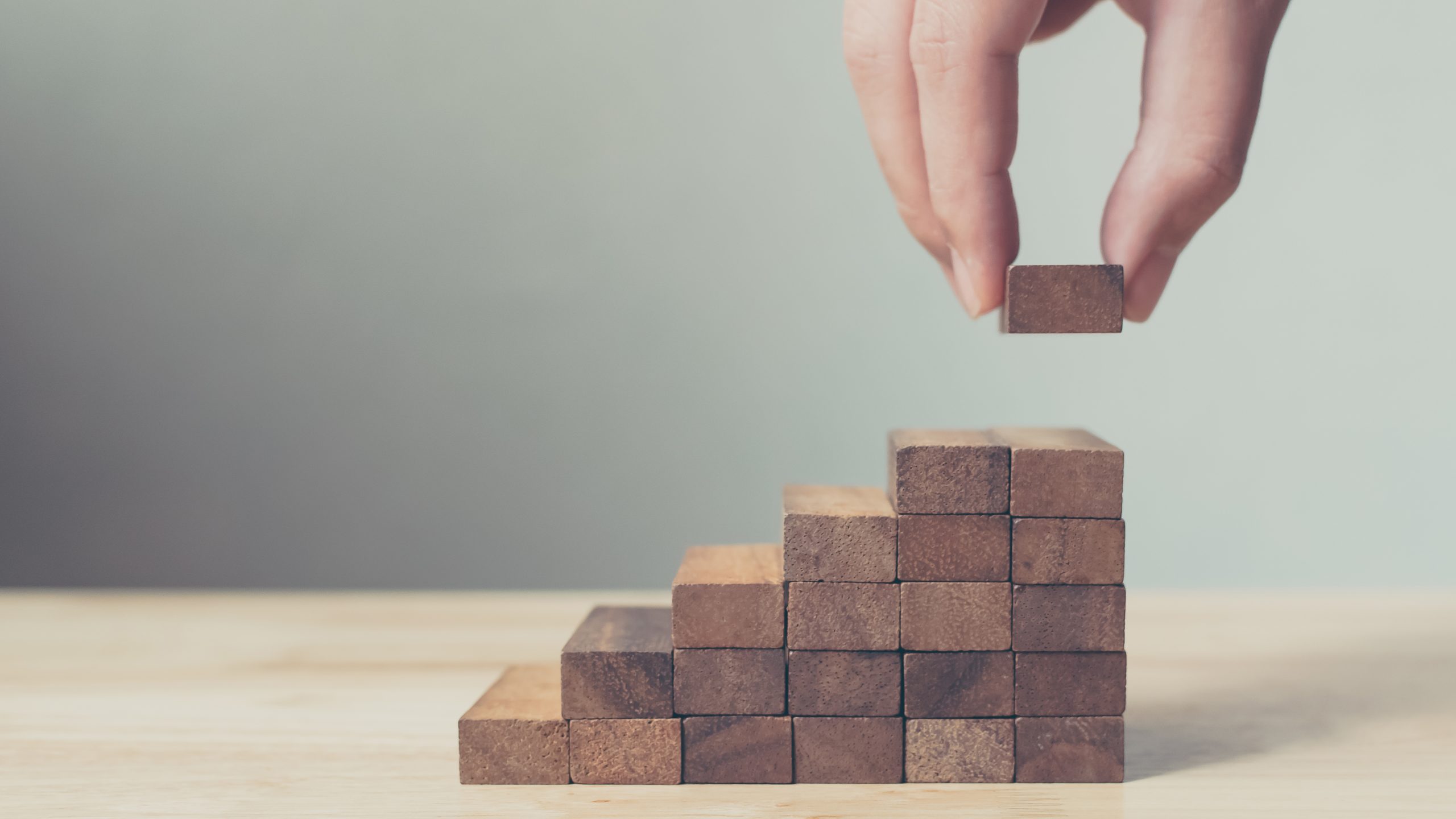 hand stacking wooden blocks in stair case form